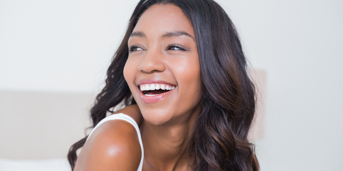 Woman smiling confidently after cosmetic dentistry or orthodontic treatment